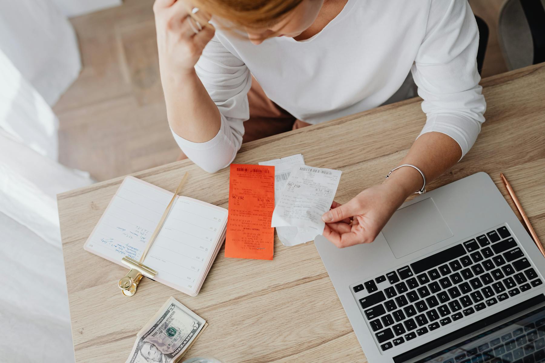 Business owner reviewing receipts and monthly bookkeeping records at a desk