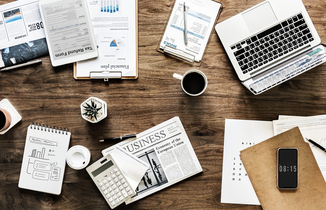 Finance documents, laptop, calculator, and planning papers on a desk