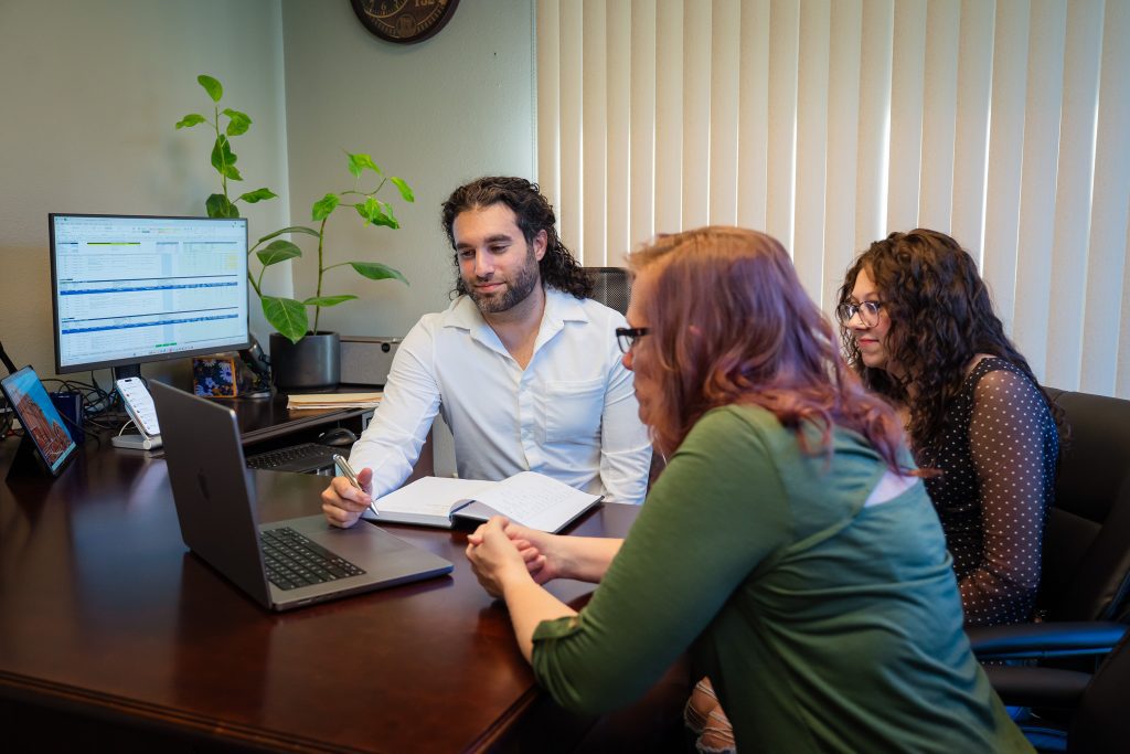 DeMar Consulting Group consultation around a laptop at the Reno office